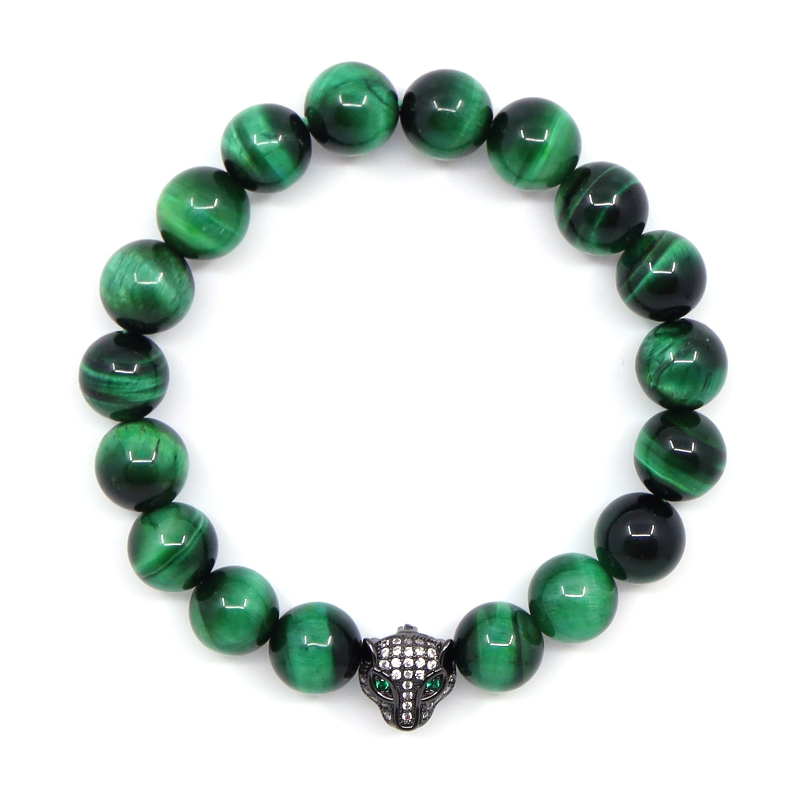 Overhead view of a green tiger's eye bracelet with round banded beads and a black jaguar head set with clear stones and green eyes.