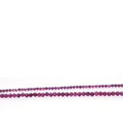 Close-up of faceted natural ruby beads showing variations in pink-red colour and texture.