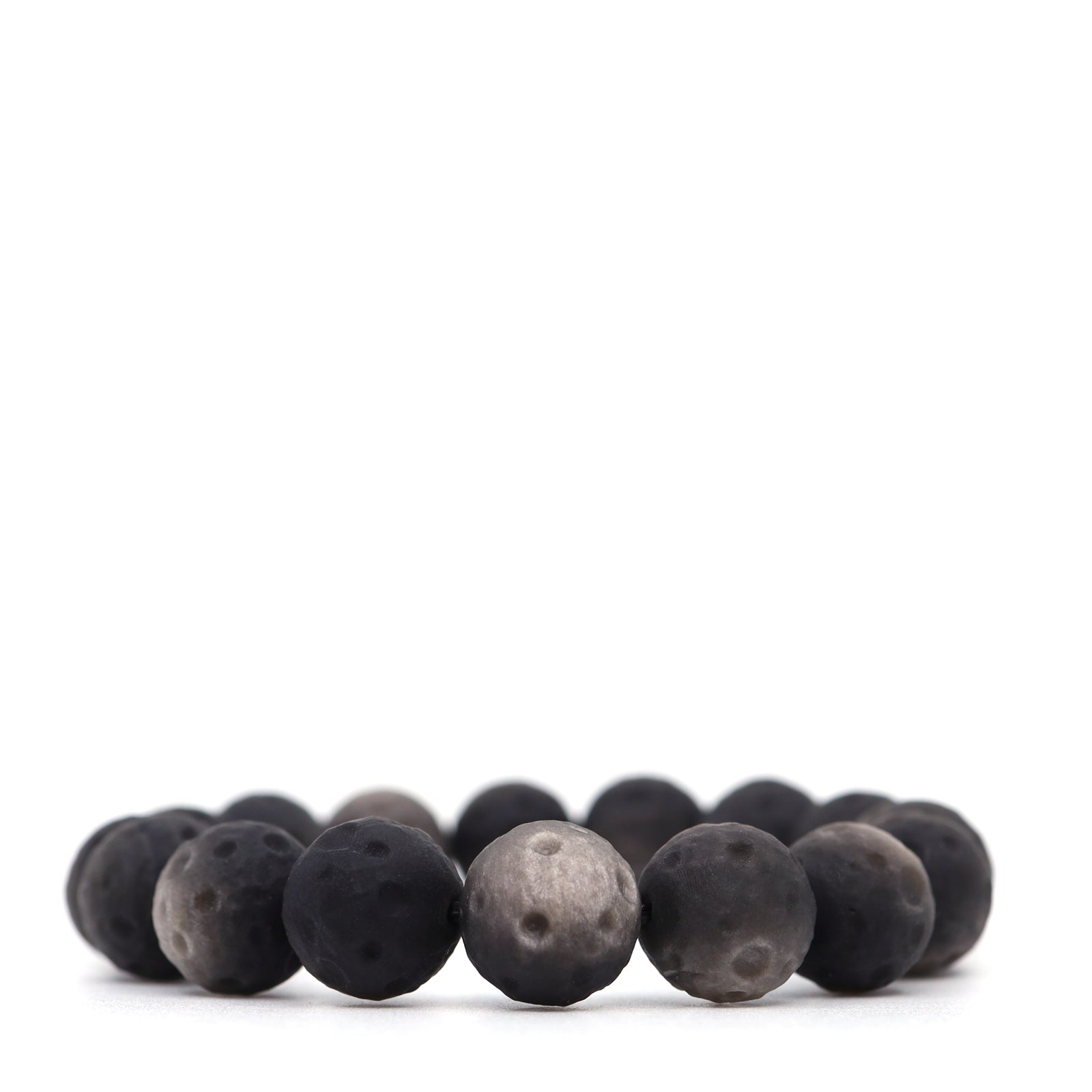 Silver obsidian bracelet with matte round beads, crater-like dimples and silver-grey highlights, shown from a low front angle.